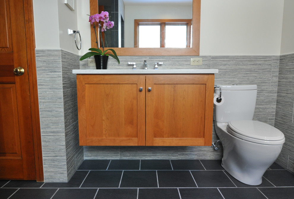 Mid-sized trendy master gray tile and ceramic tile ceramic tile bathroom photo in Boston with an undermount sink, flat-panel cabinets, medium tone wood cabinets, quartz countertops, a two-piece toilet and gray walls