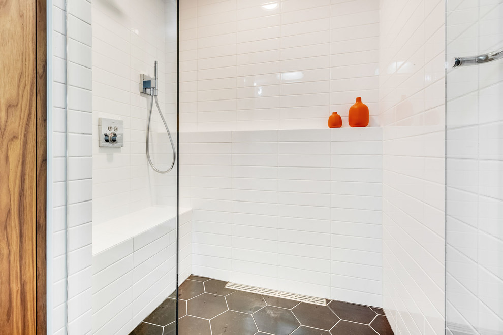 Bild på ett mellanstort funkis vit vitt badrum med dusch, med möbel-liknande, vita skåp, en dusch i en alkov, en toalettstol med hel cisternkåpa, vit kakel, keramikplattor, grå väggar, klinkergolv i porslin, ett integrerad handfat, grått golv och dusch med skjutdörr