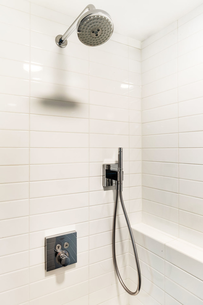Cette image montre une salle de bain design de taille moyenne avec un placard en trompe-l'oeil, des portes de placard blanches, WC à poser, un carrelage blanc, des carreaux de céramique, un mur gris, un sol en carrelage de porcelaine, un lavabo intégré, un sol gris, une cabine de douche à porte coulissante et un plan de toilette blanc.