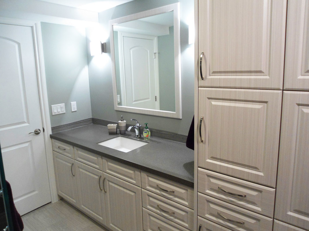 Modern inredning av ett mellanstort grå grått badrum med dusch, med luckor med upphöjd panel, vita skåp, en hörndusch, grå väggar, klinkergolv i porslin, ett undermonterad handfat, bänkskiva i akrylsten, beiget golv och dusch med gångjärnsdörr