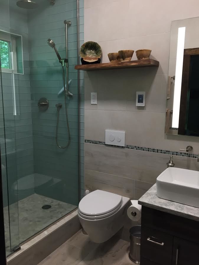 Idées déco pour une salle de bain contemporaine en bois foncé de taille moyenne avec WC suspendus, un carrelage bleu, un carrelage en pâte de verre, un mur beige, une vasque, un plan de toilette en marbre, un sol beige et une cabine de douche à porte coulissante.