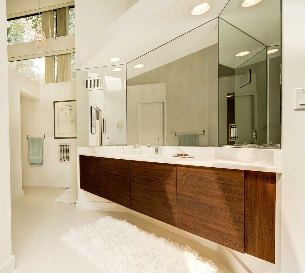Immagine di una grande stanza da bagno minimal con ante lisce, ante in legno scuro e top in marmo