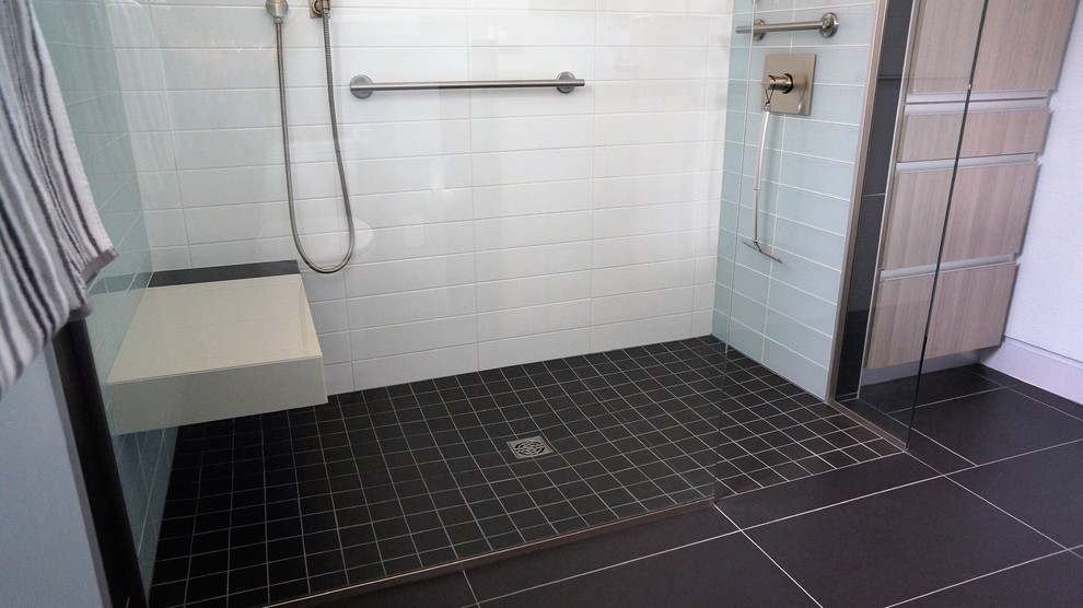 Réalisation d'une petite salle de bain principale design en bois clair avec un placard à porte plane, une douche ouverte, WC à poser, un carrelage gris, un carrelage en pâte de verre, un mur gris, un sol en carrelage de porcelaine, un lavabo encastré, un plan de toilette en quartz modifié, un sol noir et une cabine de douche à porte battante.