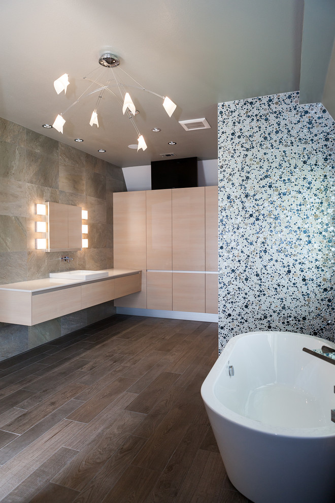 Idéer för att renovera ett mellanstort funkis en-suite badrum, med släta luckor, vita skåp, ett fristående badkar, en öppen dusch, grå kakel, skifferkakel, grå väggar, mörkt trägolv, ett nedsänkt handfat och bänkskiva i akrylsten
