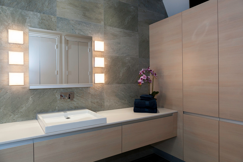 Idéer för mellanstora funkis en-suite badrum, med släta luckor, vita skåp, ett fristående badkar, en öppen dusch, grå kakel, skifferkakel, grå väggar, mörkt trägolv, ett nedsänkt handfat och bänkskiva i akrylsten