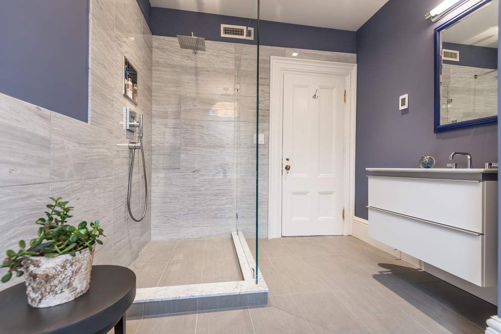 This is an example of a medium sized contemporary ensuite bathroom in Boston with flat-panel cabinets, white cabinets, purple walls, an integrated sink, a walk-in shower, a one-piece toilet, beige tiles, porcelain tiles, porcelain flooring, solid surface worktops and an open shower.