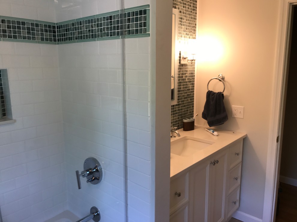Design ideas for a medium sized contemporary family bathroom in Providence with recessed-panel cabinets, white cabinets, an alcove bath, a shower/bath combination, a two-piece toilet, blue tiles, green tiles, mosaic tiles, white walls, light hardwood flooring, a submerged sink, solid surface worktops, beige floors and a sliding door.