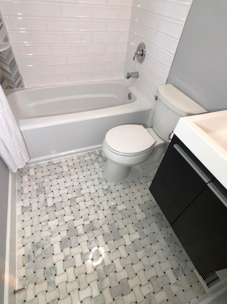 Example of a small trendy white tile and porcelain tile travertine floor bathroom design in Baltimore with flat-panel cabinets, black cabinets, a two-piece toilet, gray walls and quartz countertops