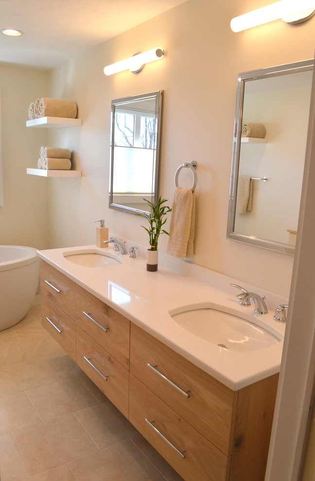Photo of a large contemporary ensuite bathroom in Boston with light wood cabinets, a freestanding bath, a corner shower, beige tiles, a submerged sink, flat-panel cabinets, a wall mounted toilet, porcelain tiles, porcelain flooring and engineered stone worktops.