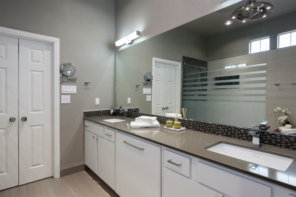 Inspiration for a mid-sized contemporary master black tile, gray tile and mosaic tile porcelain tile doorless shower remodel in Dallas with flat-panel cabinets, white cabinets, gray walls, an undermount sink and solid surface countertops