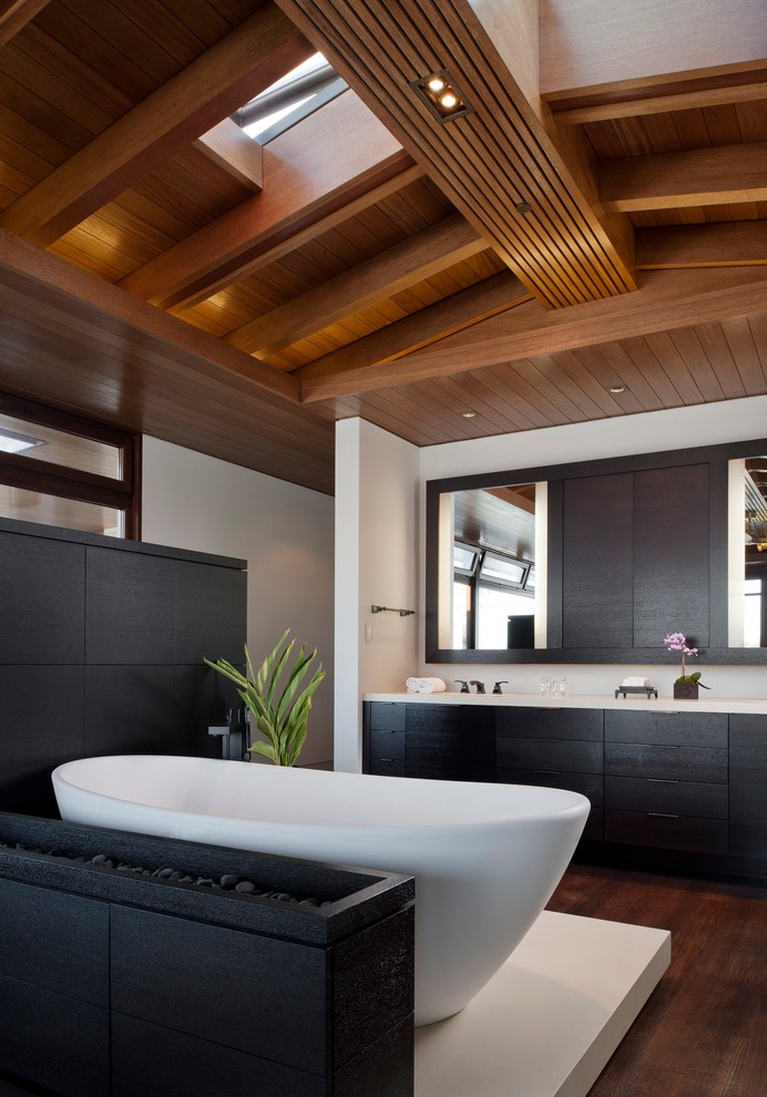 Стильный дизайн: ванная комната в современном стиле с отдельно стоящей ванной, плоскими фасадами, черными фасадами и темным паркетным полом - последний тренд