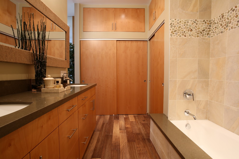 Cette image montre une salle de bain design en bois brun avec un placard à porte plane et un carrelage beige.