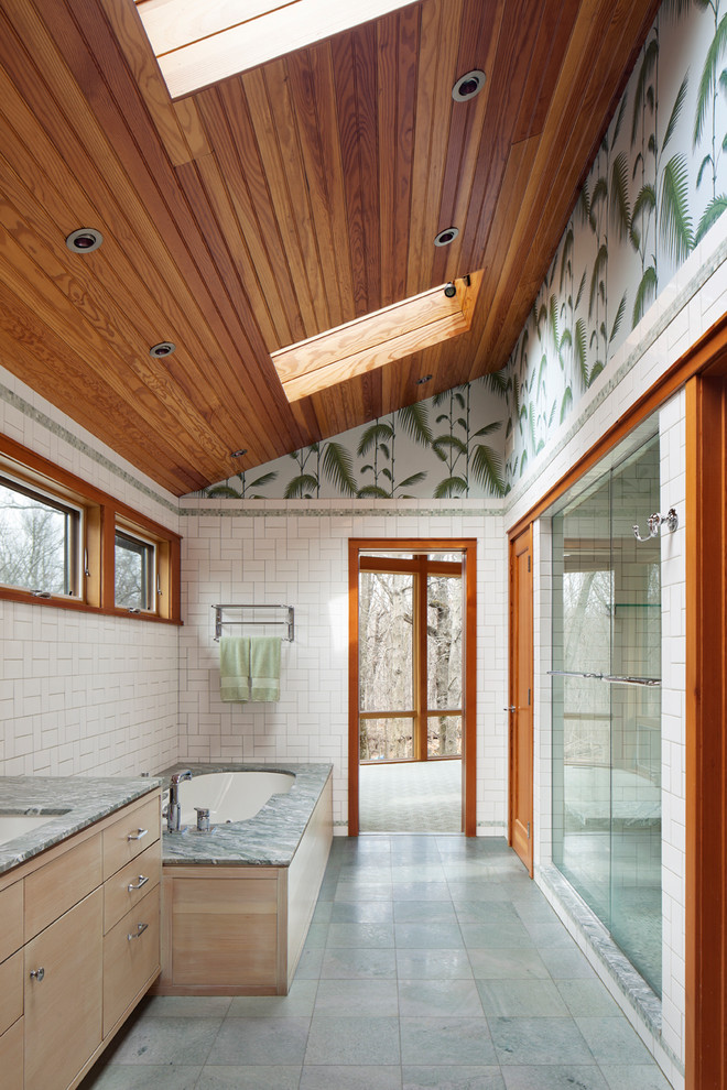 Идея дизайна: большая ванная комната в современном стиле с врезной раковиной, плоскими фасадами, светлыми деревянными фасадами, полновстраиваемой ванной, душем в нише, белой плиткой, разноцветными стенами, мраморной столешницей, раздельным унитазом, керамической плиткой, мраморным полом и серой столешницей