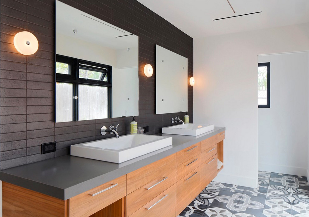 Bathroom - contemporary black tile bathroom idea in San Diego with a vessel sink, flat-panel cabinets, light wood cabinets and gray countertops