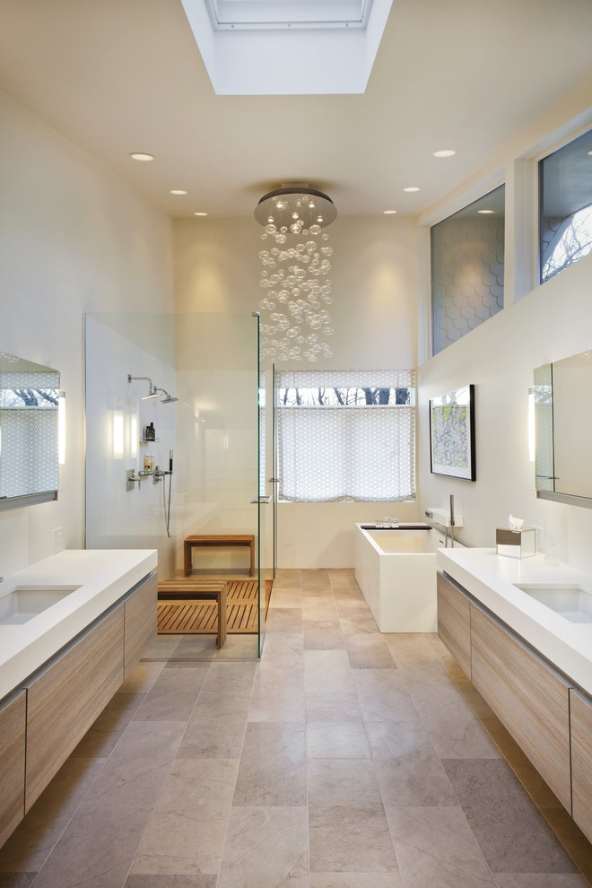 Свежая идея для дизайна: ванная комната в современном стиле с врезной раковиной, плоскими фасадами, светлыми деревянными фасадами, отдельно стоящей ванной, душем в нише и бежевой плиткой - отличное фото интерьера
