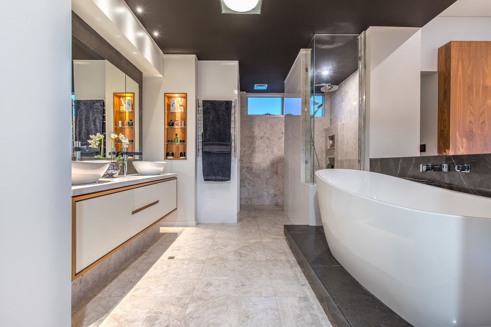 Idées déco pour une salle de bain principale contemporaine avec un placard à porte shaker, des portes de placard blanches, un mur blanc, une vasque, un sol beige, un plan de toilette gris et un mur en pierre.