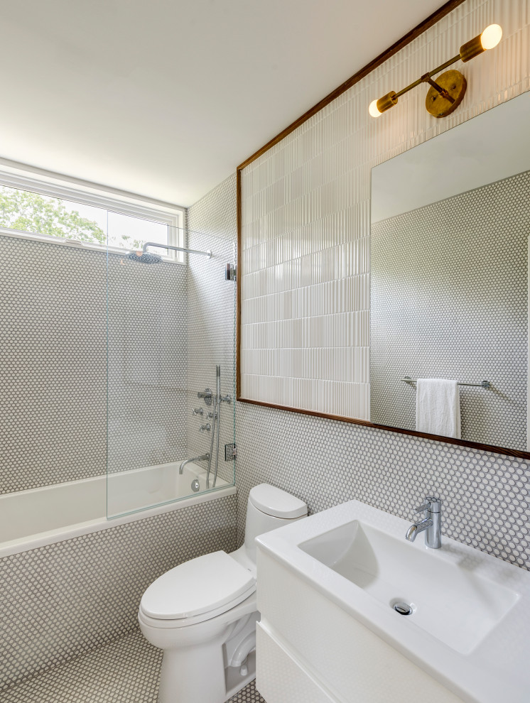 Стильный дизайн: ванная комната в современном стиле с плоскими фасадами, белыми фасадами, накладной ванной, душем над ванной, унитазом-моноблоком, белой плиткой, плиткой мозаикой, полом из мозаичной плитки, монолитной раковиной, белым полом, белой столешницей и зеркалом с подсветкой - последний тренд