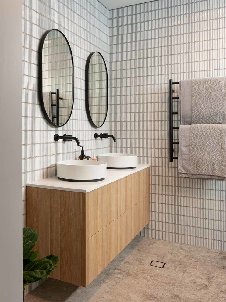 Photo of a medium sized contemporary ensuite bathroom in Sydney with medium wood cabinets, grey tiles, mosaic tiles, grey walls, porcelain flooring, a vessel sink, engineered stone worktops, grey floors, white worktops and flat-panel cabinets.