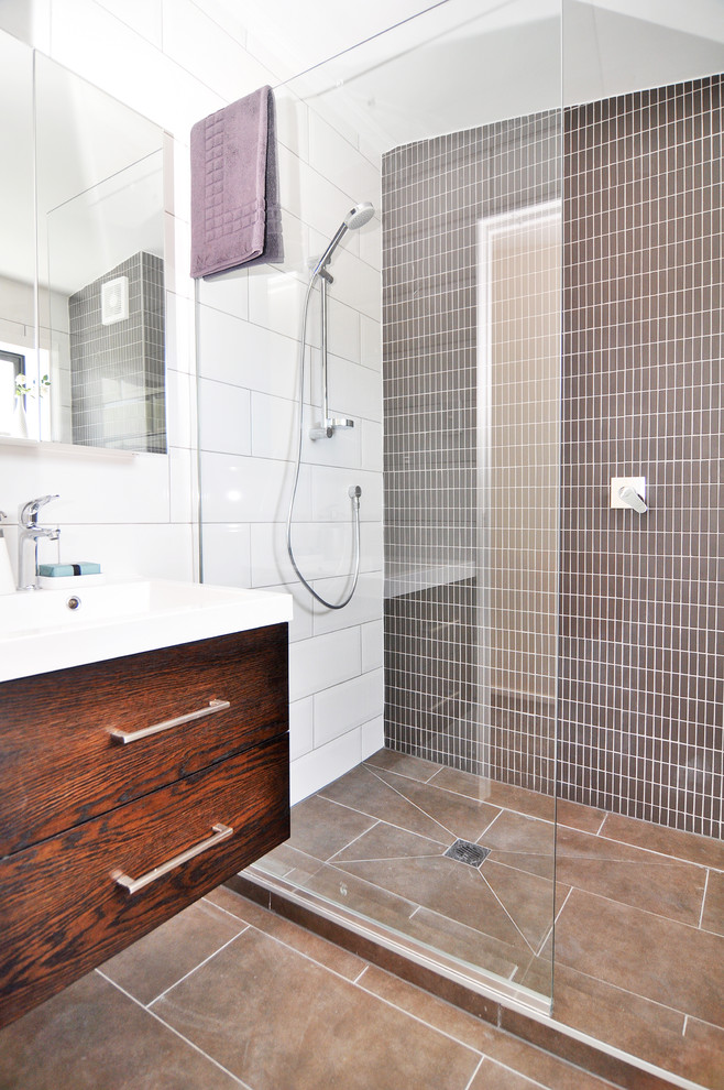 Modernes Badezimmer mit flächenbündigen Schrankfronten, dunklen Holzschränken, Duschnische und braunen Fliesen in Auckland