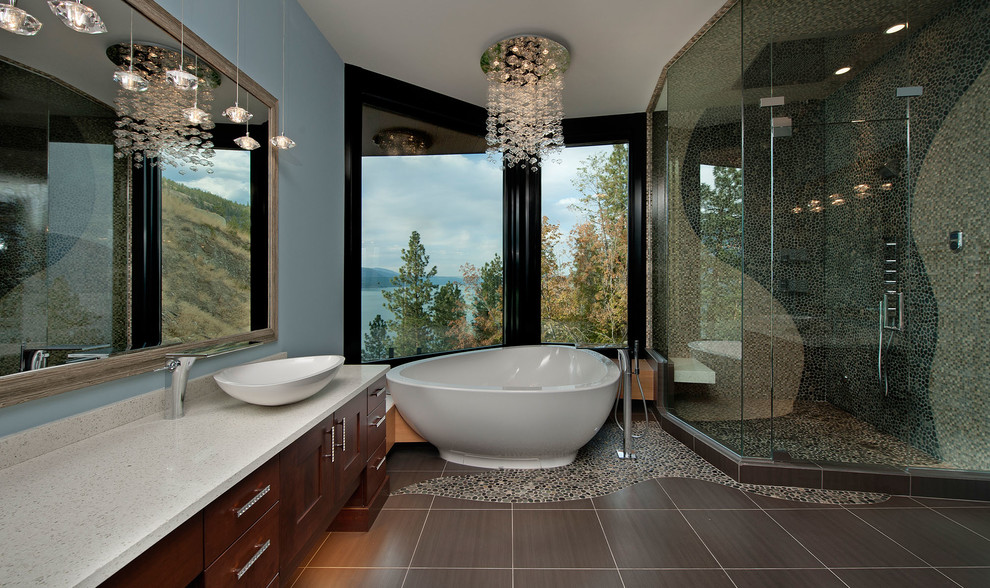 Modernes Badezimmer mit dunklen Holzschränken, freistehender Badewanne, Eckdusche, grauen Fliesen, Kieselfliesen, Kiesel-Bodenfliesen und blauer Wandfarbe in Vancouver