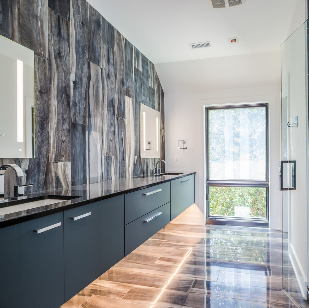 Inspiration for a contemporary bathroom in Los Angeles with flat-panel cabinets, blue cabinets, blue tiles, white walls, a submerged sink, brown floors, a hinged door and black worktops.