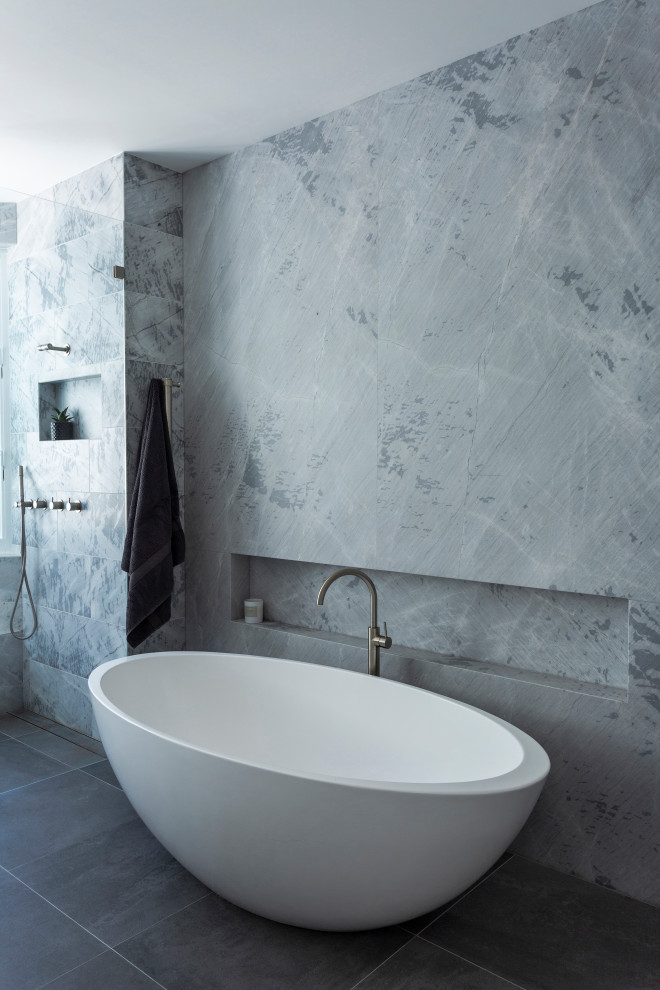 Ispirazione per una stanza da bagno minimal con vasca freestanding, piastrelle grigie, pavimento grigio, doccia aperta e nicchia