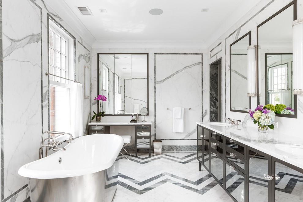 Réalisation d'une salle de bain design avec un placard à porte vitrée, des portes de placard grises, une baignoire indépendante, un carrelage gris, un carrelage blanc, un mur blanc et un lavabo encastré.