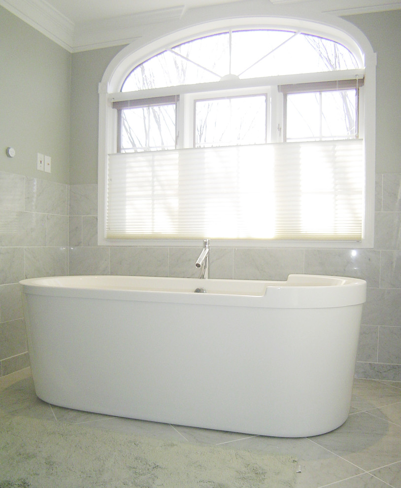 Cette image montre une grande douche en alcôve principale design avec un lavabo suspendu, une baignoire indépendante, un carrelage gris, un carrelage de pierre, un mur gris, un sol en marbre et WC suspendus.