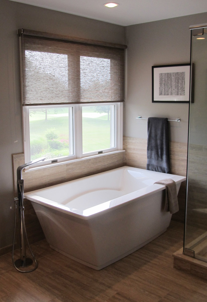 Idéer för att renovera ett mellanstort funkis en-suite badrum, med ett fristående badkar, en hörndusch, en toalettstol med hel cisternkåpa, beige kakel, stenkakel, grå väggar och klinkergolv i porslin
