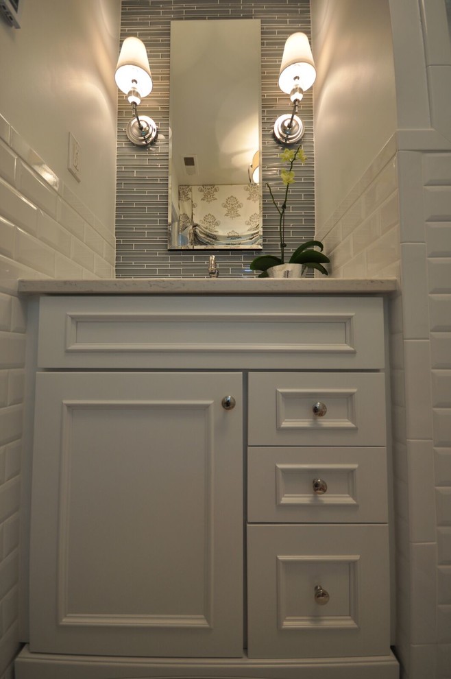 Bild på ett mellanstort orientaliskt badrum med dusch, med luckor med infälld panel, vita skåp, grå kakel, vit kakel, tunnelbanekakel, bänkskiva i kvarts, en dusch i en alkov, en toalettstol med separat cisternkåpa, vita väggar, ett undermonterad handfat och klinkergolv i keramik