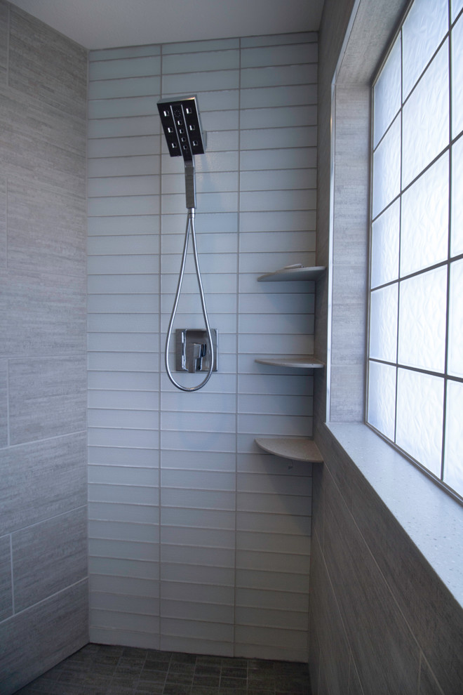 На фото: большая главная ванная комната в современном стиле с фасадами с декоративным кантом, белыми фасадами, серой плиткой, серыми стенами, полом из керамогранита, угловым душем, стеклянной плиткой и серым полом