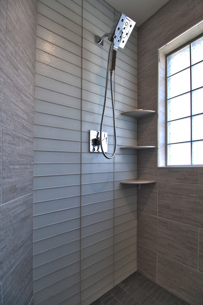 Cette photo montre une grande salle de bain principale tendance avec une douche d'angle, un carrelage gris, un carrelage en pâte de verre, un mur gris et un sol gris.