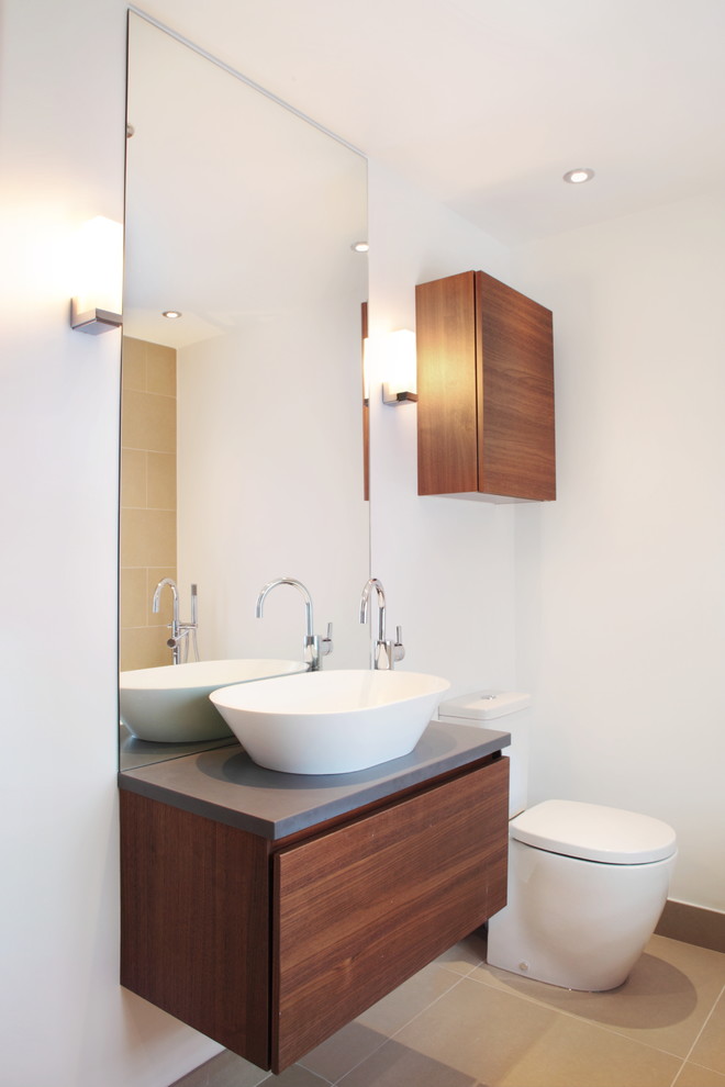 Inspiration för ett mellanstort funkis badrum, med släta luckor, bänkskiva i akrylsten, skåp i mörkt trä och vita väggar