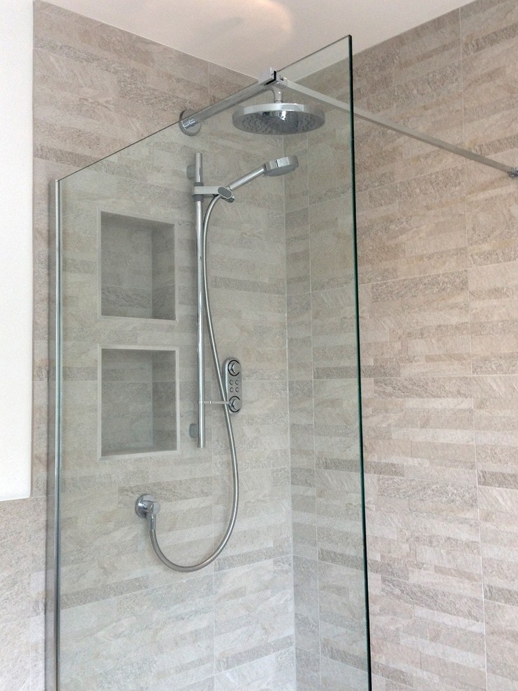 This is an example of a contemporary family bathroom in Berkshire with a walk-in shower, a one-piece toilet, grey tiles, porcelain tiles, grey walls and porcelain flooring.