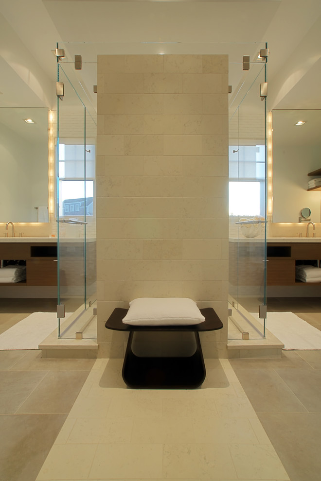 Example of a trendy beige tile and limestone tile alcove shower design in Other with flat-panel cabinets and dark wood cabinets