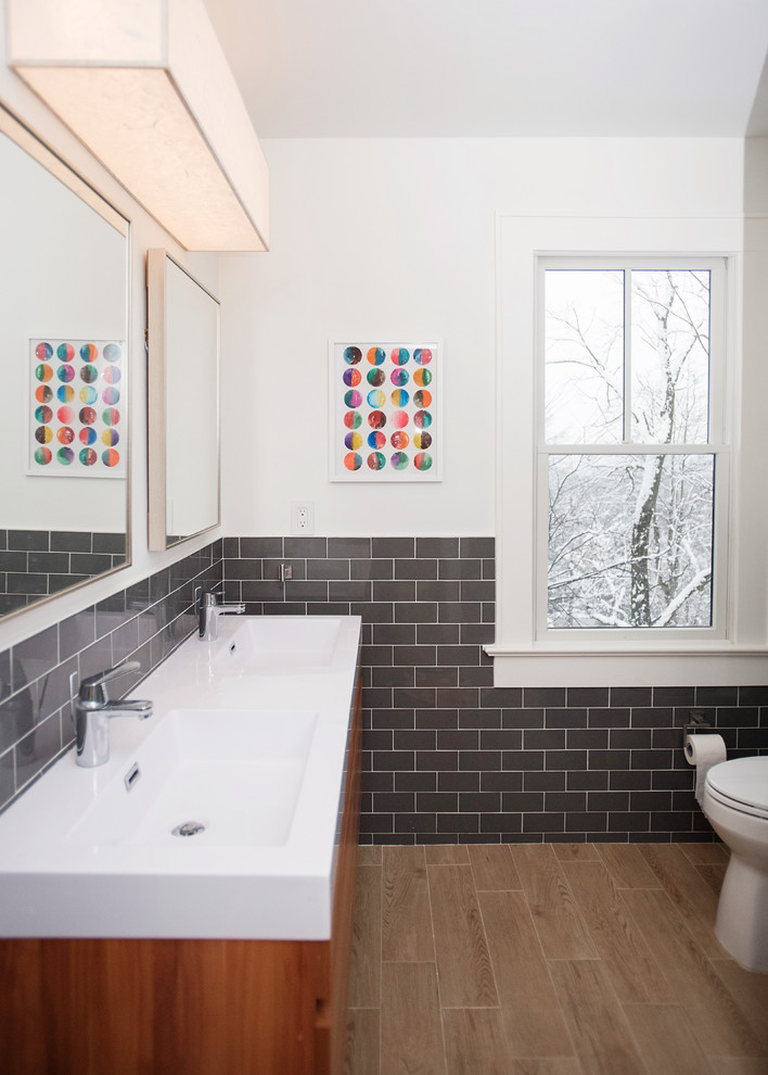 На фото: ванная комната в современном стиле с плоскими фасадами, фасадами цвета дерева среднего тона, белыми стенами, паркетным полом среднего тона, монолитной раковиной, коричневым полом и белой столешницей с