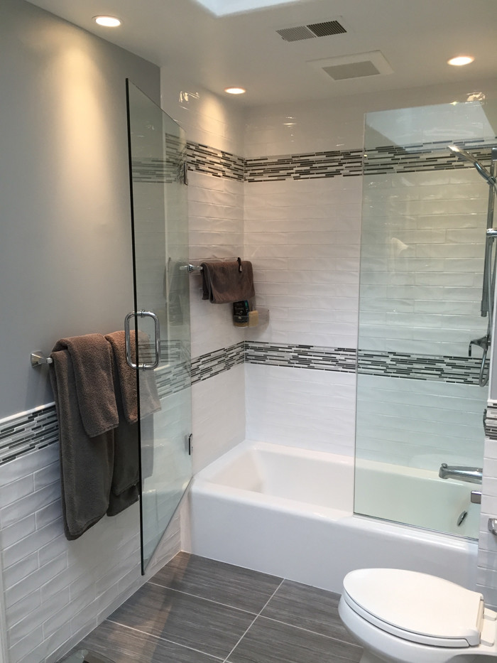 Example of a mid-sized trendy kids' white tile and ceramic tile porcelain tile and gray floor bathroom design in Philadelphia with shaker cabinets, gray cabinets, a one-piece toilet, gray walls, an integrated sink, quartz countertops, a hinged shower door and white countertops