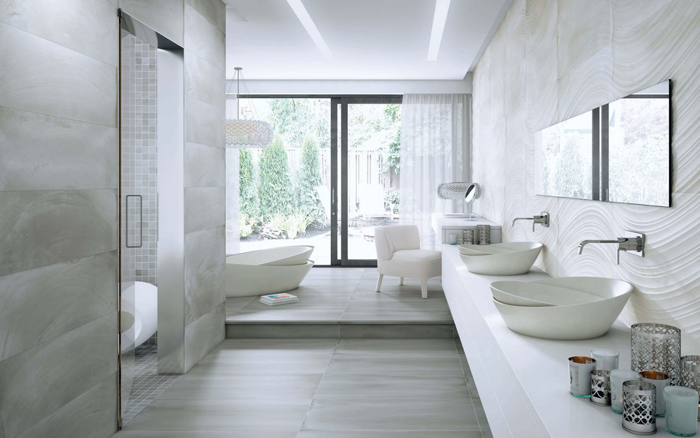 Modern inredning av ett mellanstort en-suite badrum, med släta luckor, vita skåp, ett platsbyggt badkar, en öppen dusch, en toalettstol med hel cisternkåpa, vit kakel, stenkakel, vita väggar, ljust trägolv, ett piedestal handfat och bänkskiva i akrylsten