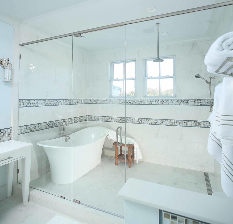 На фото: большая главная ванная комната в морском стиле с отдельно стоящей ванной, белой плиткой, мраморной плиткой, синими стенами и мраморным полом