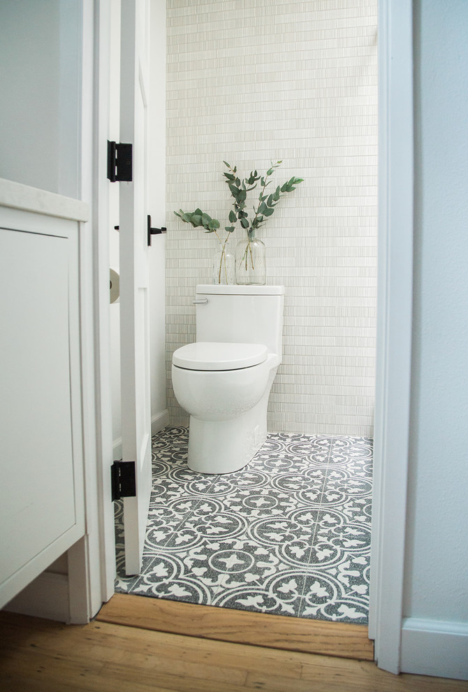 Small minimalist 3/4 white tile and ceramic tile cement tile floor and black floor bathroom photo in Orange County with flat-panel cabinets, white cabinets, a one-piece toilet, white walls, an undermount sink, quartz countertops and white countertops
