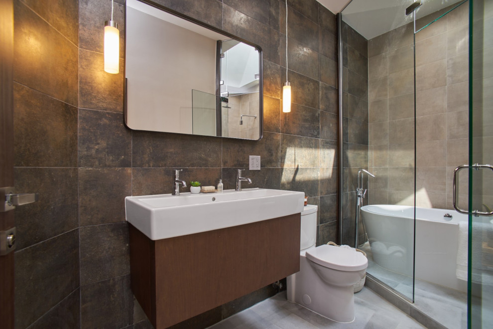 Large trendy master brown tile and porcelain tile porcelain tile, gray floor, double-sink and tray ceiling bathroom photo in New York with flat-panel cabinets, dark wood cabinets, a two-piece toilet, beige walls, a vessel sink, solid surface countertops, a hinged shower door, white countertops, a niche and a floating vanity