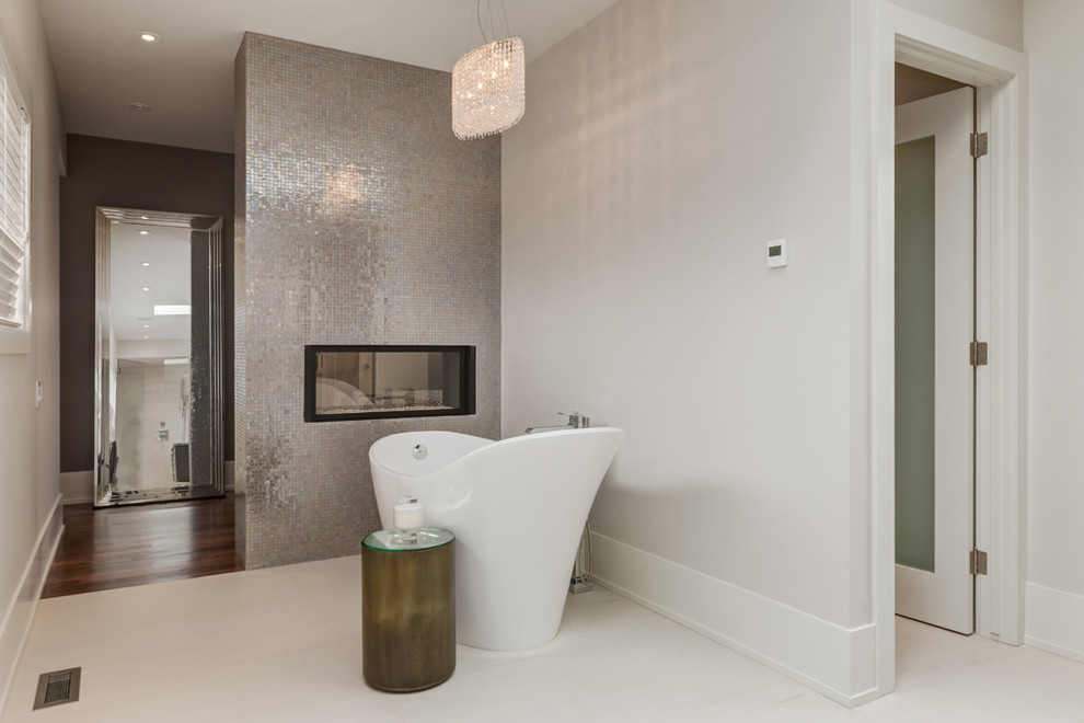 Modelo de cuarto de baño contemporáneo con bañera exenta, baldosas y/o azulejos grises, baldosas y/o azulejos de metal, paredes blancas y suelo de baldosas de porcelana