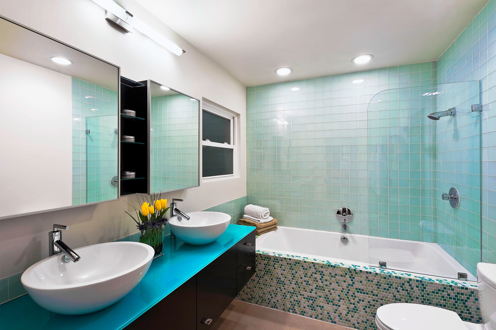 Cette photo montre une salle de bain tendance avec une vasque, un placard à porte plane, une baignoire en alcôve, un combiné douche/baignoire, un carrelage multicolore, mosaïque et un plan de toilette bleu.