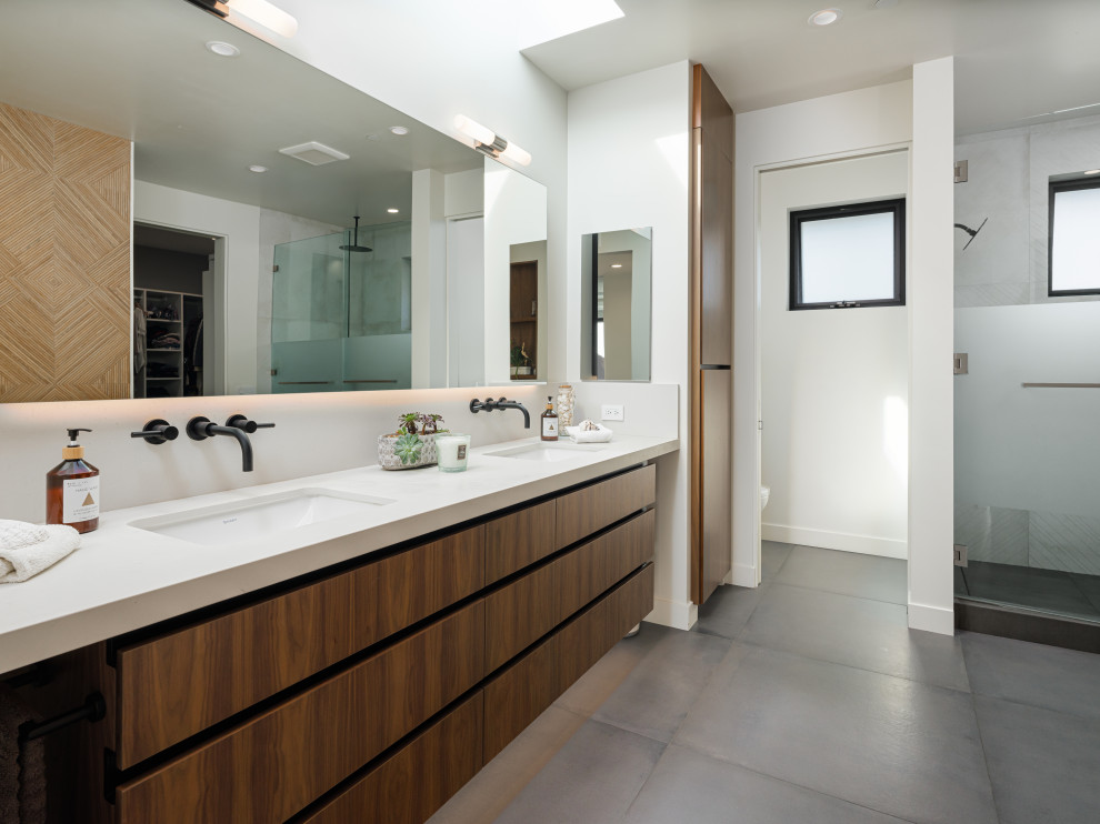 Modernes Badezimmer mit flächenbündigen Schrankfronten, hellbraunen Holzschränken, Duschnische, weißer Wandfarbe, Unterbauwaschbecken, grauem Boden, weißer Waschtischplatte, WC-Raum, Doppelwaschbecken und schwebendem Waschtisch in San Diego