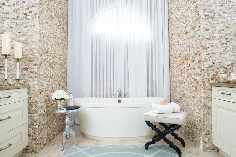 Immagine di una stanza da bagno padronale classica con ante con bugna sagomata, ante beige, vasca freestanding e pavimento beige