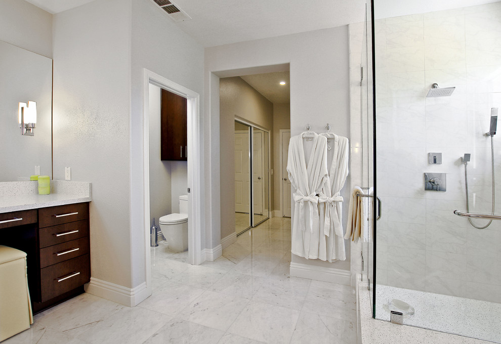 Foto på ett stort funkis en-suite badrum, med en toalettstol med hel cisternkåpa, grå väggar, marmorgolv, ett platsbyggt badkar, en hörndusch, ett undermonterad handfat, släta luckor och skåp i mörkt trä