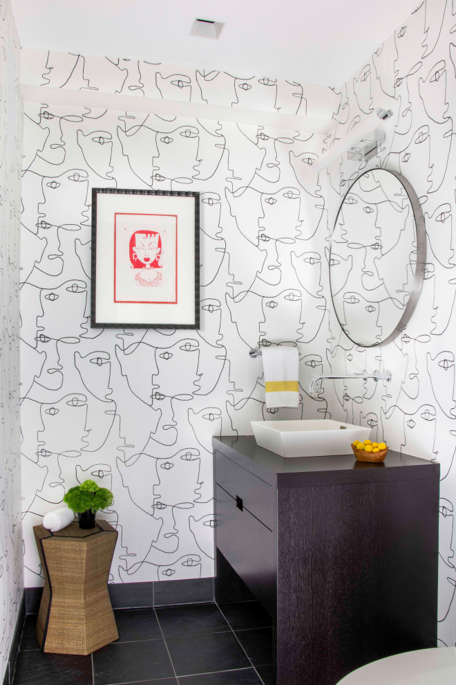 Foto på ett mellanstort funkis svart badrum, med släta luckor, svarta skåp, svart och vit kakel, svarta väggar, klinkergolv i keramik, ett fristående handfat, träbänkskiva och svart golv
