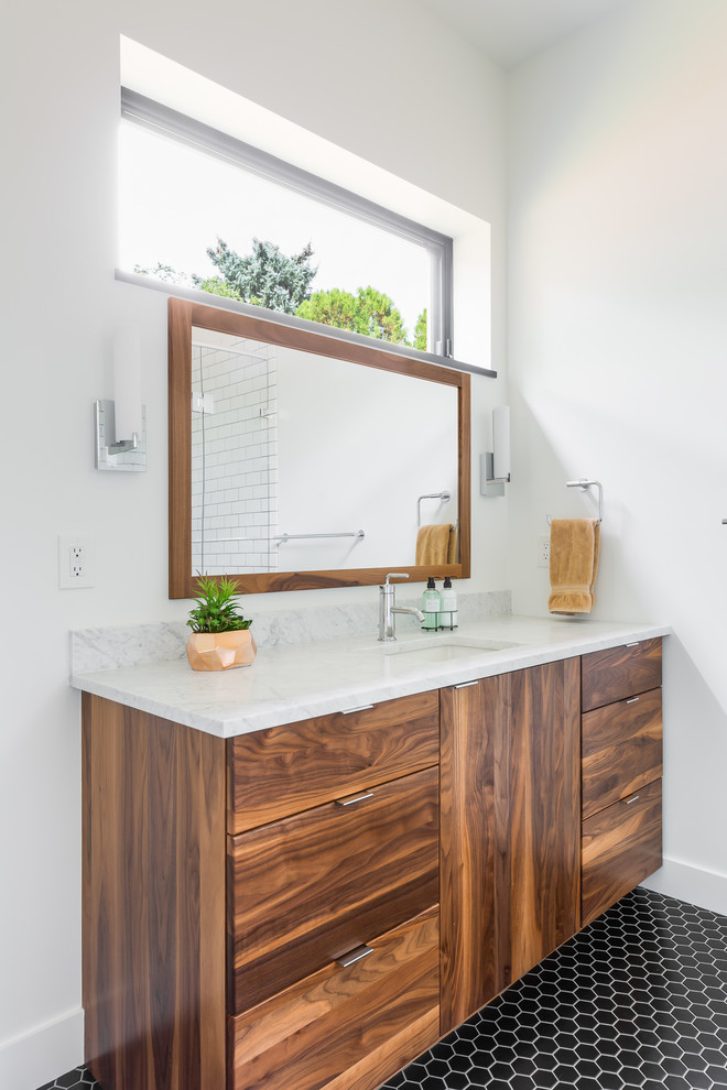 Modernes Badezimmer mit flächenbündigen Schrankfronten, hellbraunen Holzschränken, weißer Wandfarbe, Mosaik-Bodenfliesen, Unterbauwaschbecken, schwarzem Boden und weißer Waschtischplatte in Denver