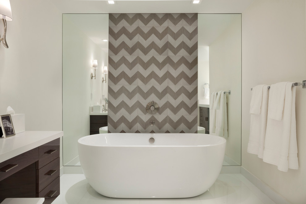 Example of a trendy master gray tile and glass tile freestanding bathtub design in Miami with flat-panel cabinets, dark wood cabinets, quartz countertops and white walls