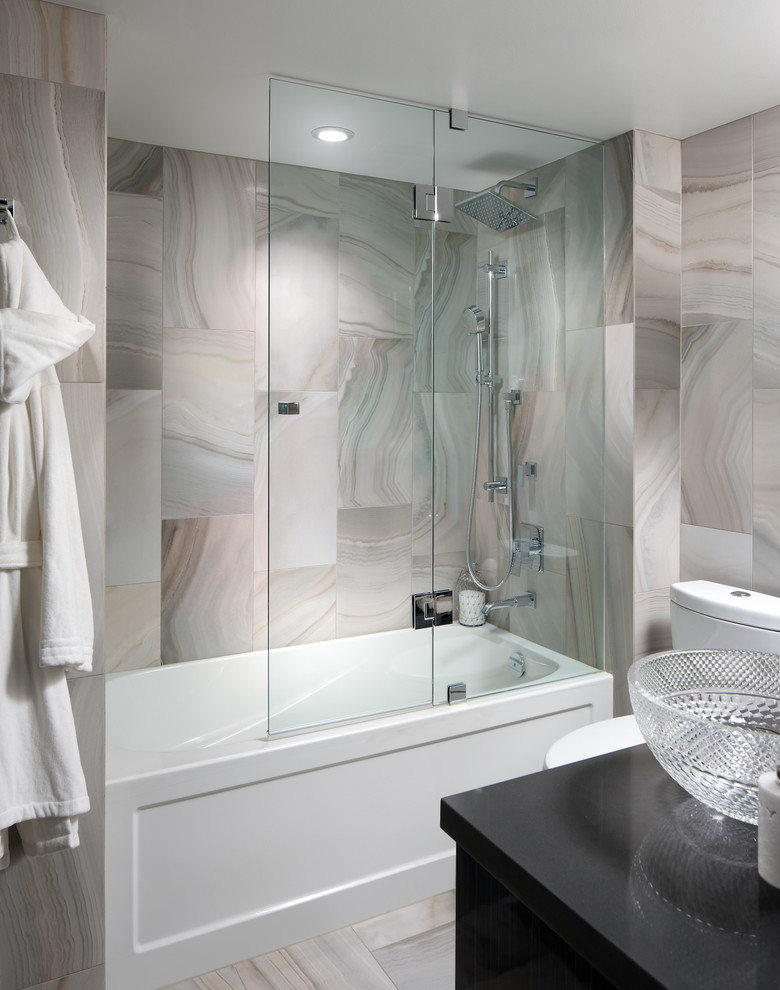На фото: ванная комната в современном стиле с ванной в нише, душем над ванной и серой плиткой